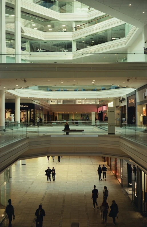 group of people walking around inside of an empty mall