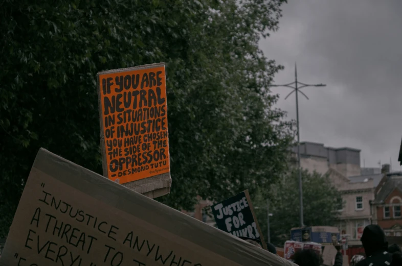 an orange sign that reads no place to hate outside the fence