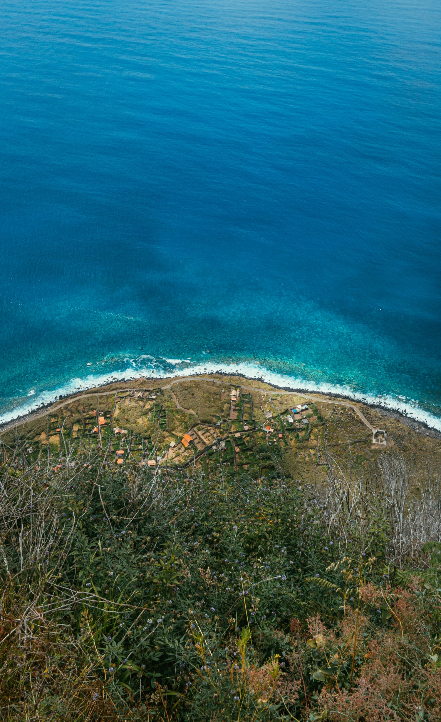 the view from above of an ocean with an island and beach area