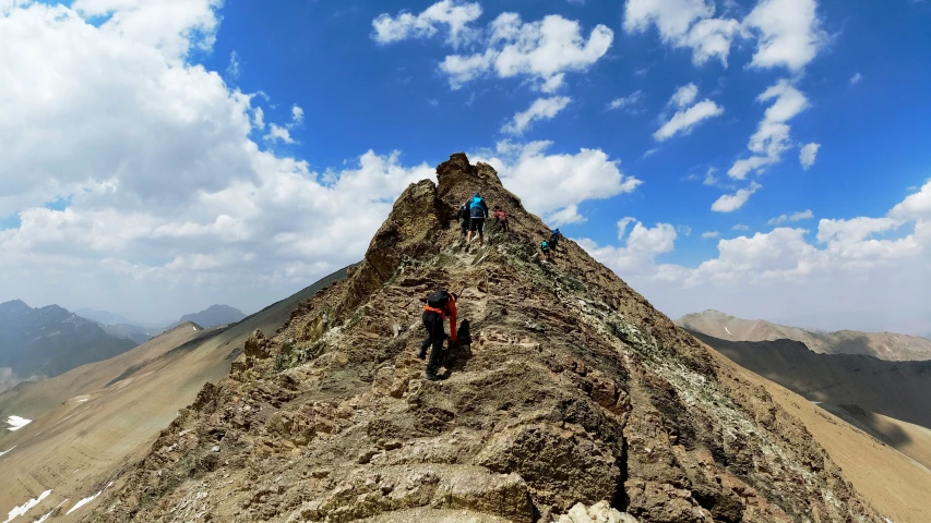 a group of climbers atop the top of a hill