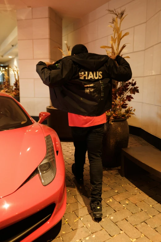 a man walking away from a red sports car