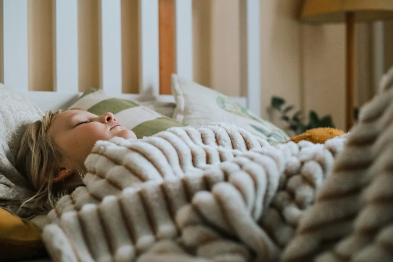 a little girl that is laying down in a bed