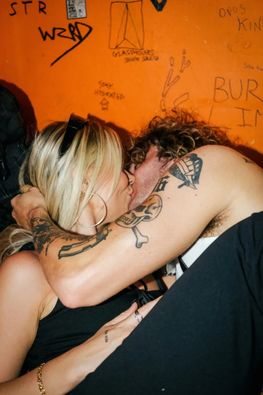 a man and a woman hug in the middle of a room covered with graffiti