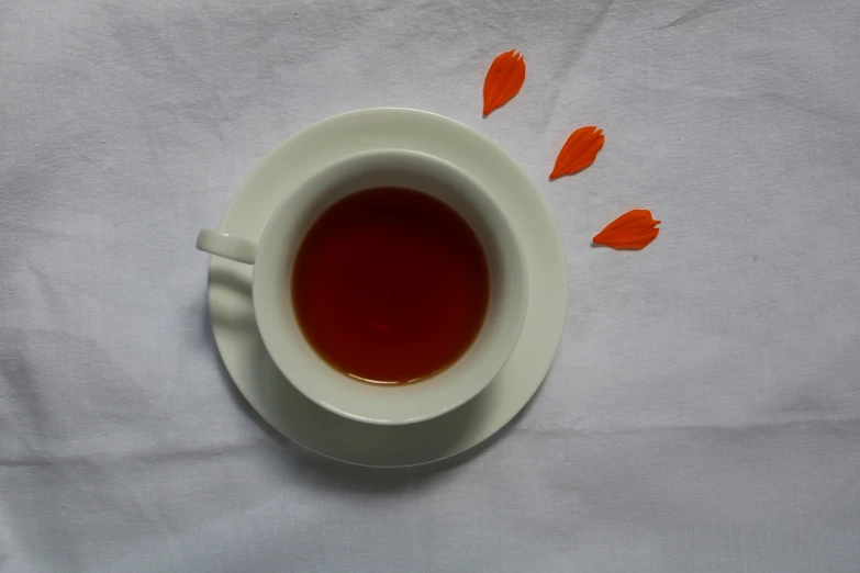 there is a cup of tea with a red dot on it