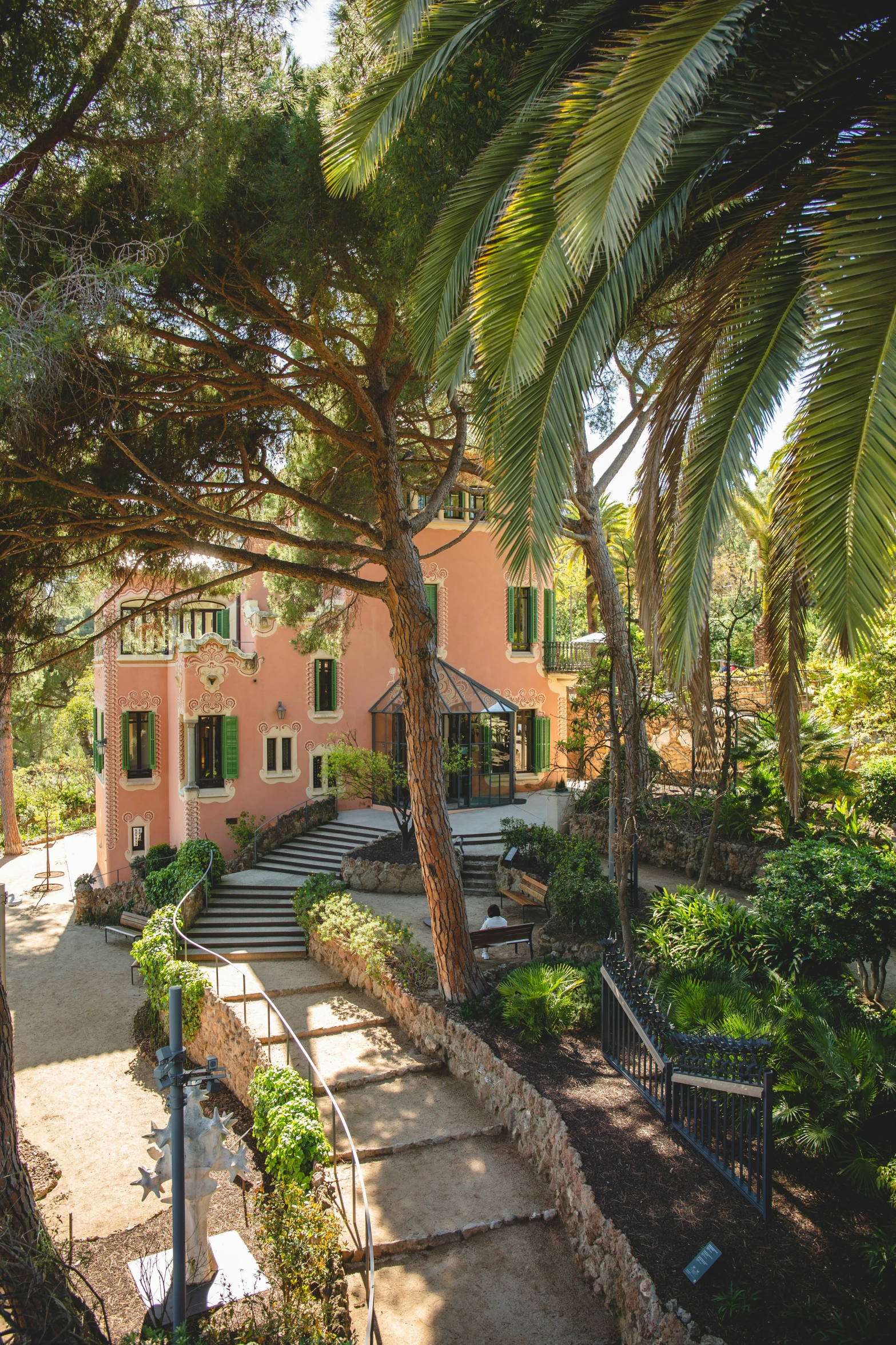 a beautiful pink house surrounded by trees and shrubs