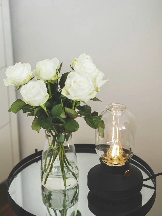 white roses are sitting in a glass vase on a table