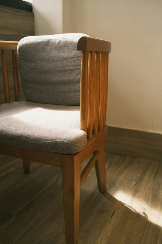 an empty wooden chair on the ground by a window