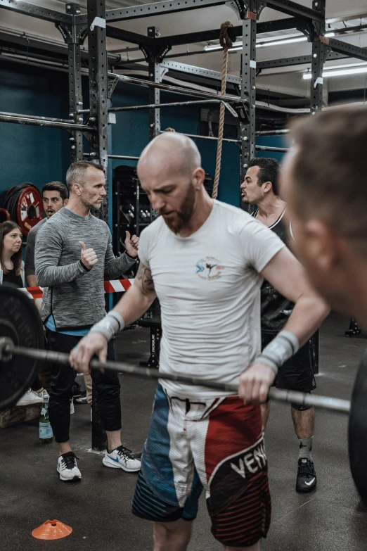 several people standing around a bar and squatting