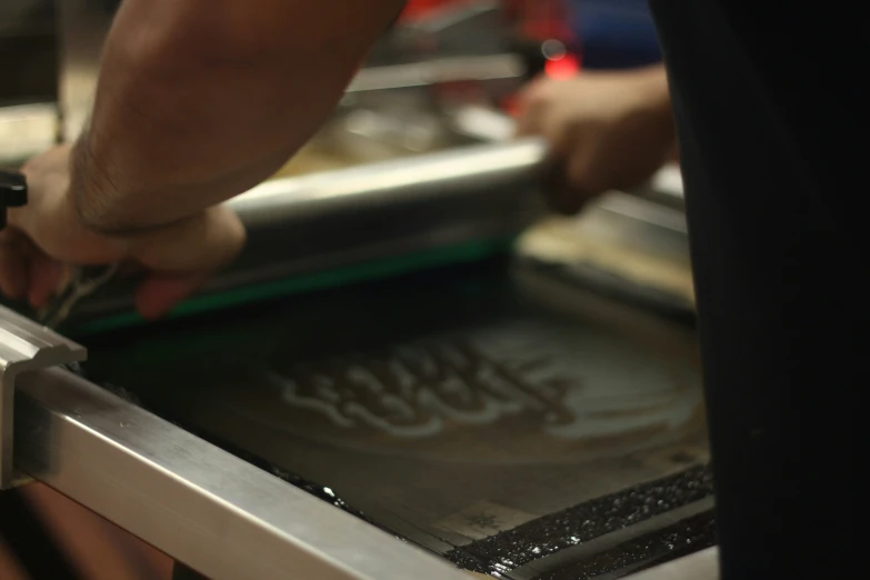 the hands on the table are working with the food