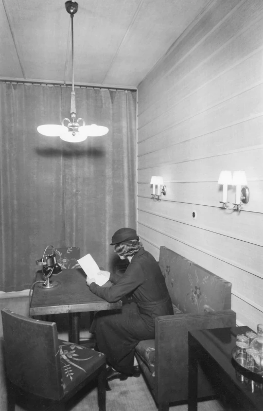 a man sitting at a table writing on paper