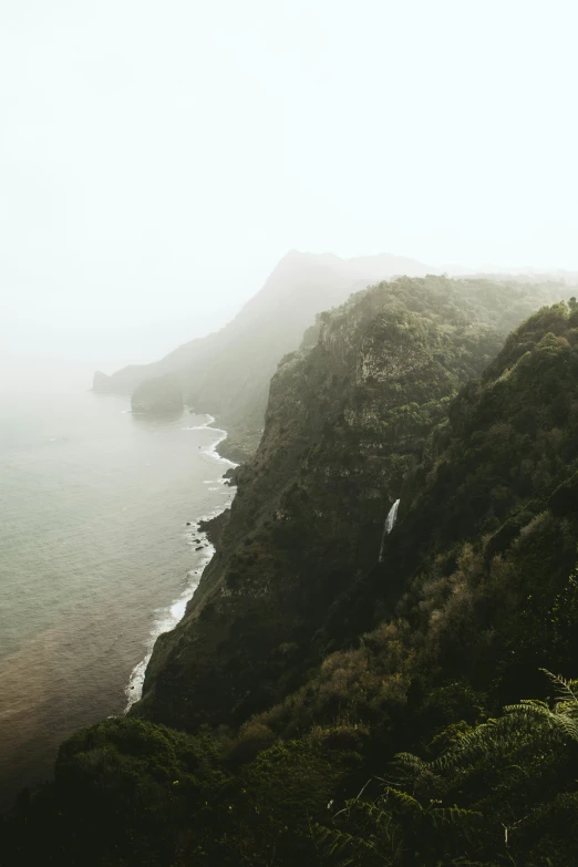 a hillside with a steep mountain next to the water