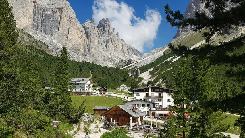 a valley with houses in it with a mountain side behind