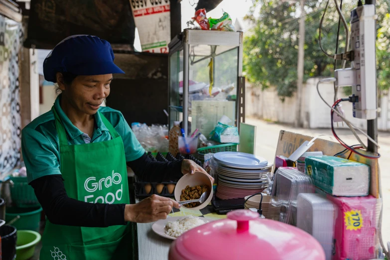 a person in a green apron preparing food on a table