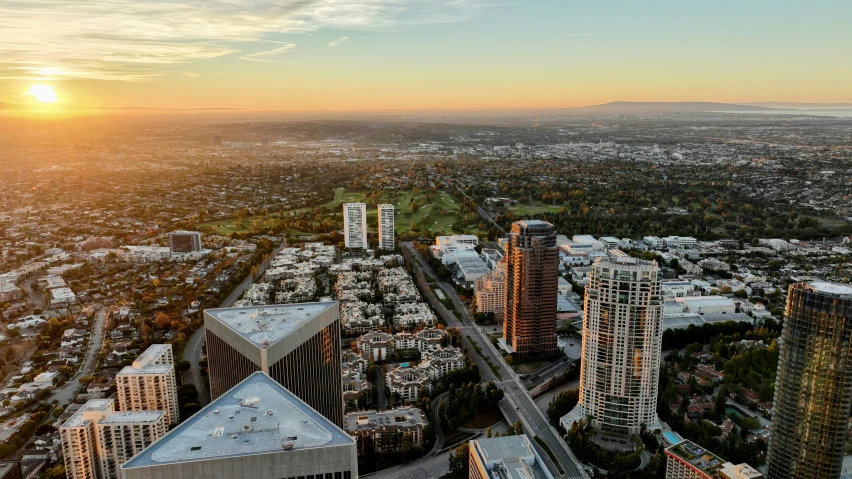 a large city is at sunset with tall buildings and a freeway