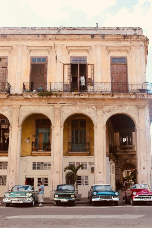 a bunch of old cars parked outside an apartment building