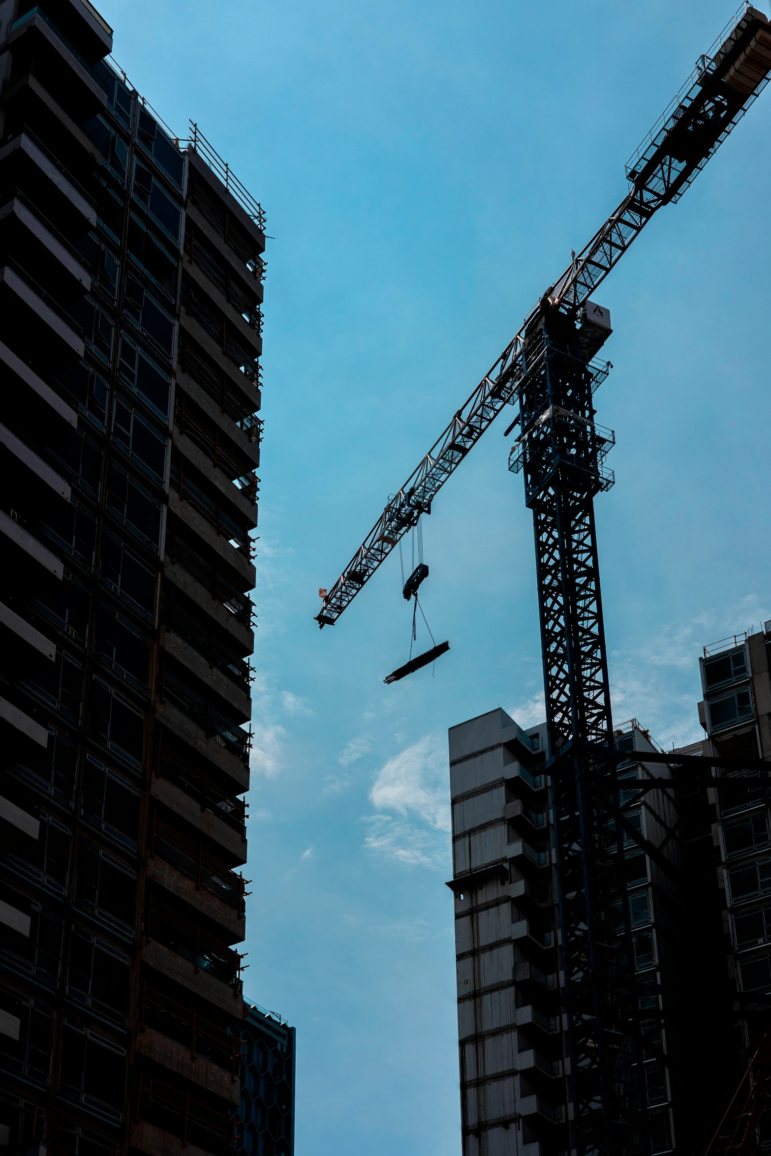 some buildings are under construction and the crane has just lifted