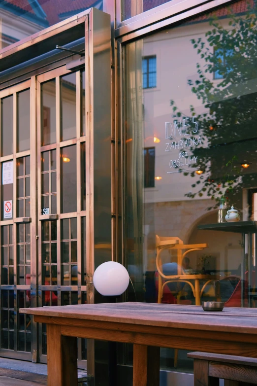 a bench and a table are outside near glass windows