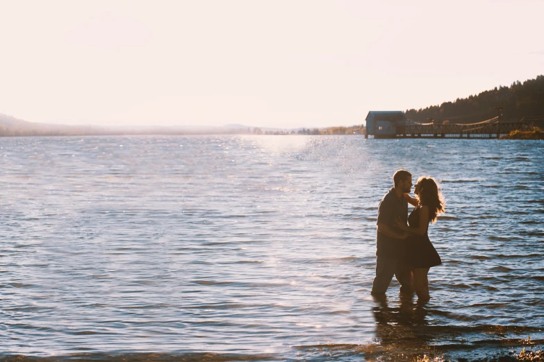 a man and woman emcing in the middle of water