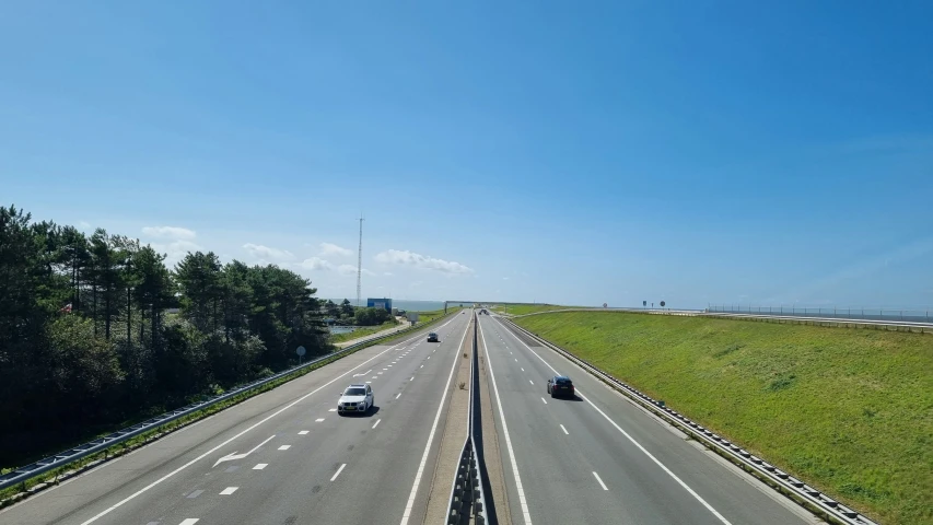 two cars travelling down the road with two on ramps