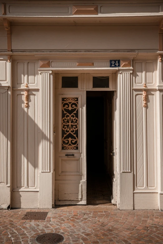 a large white building with doorway and clock at the top of it