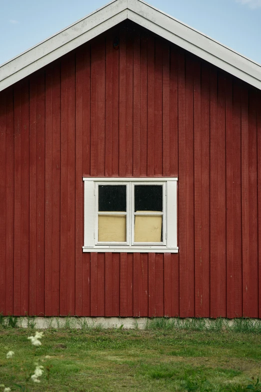 a red barn has white windows in it