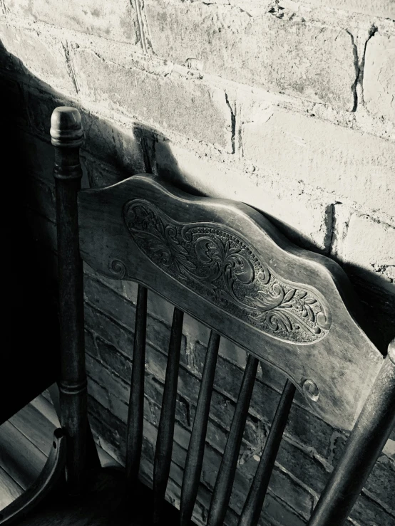 an old wooden chair sitting against a wall
