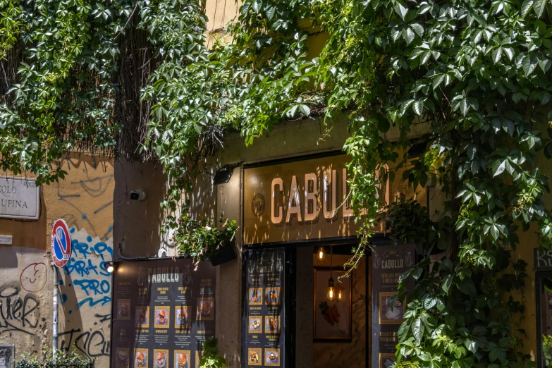 the sign for a wine shop sits in the shade