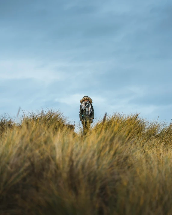 a man standing in the grass looking down