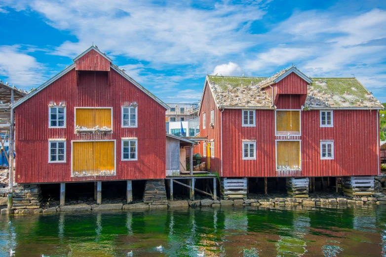 two red wooden houses are sitting on the pier