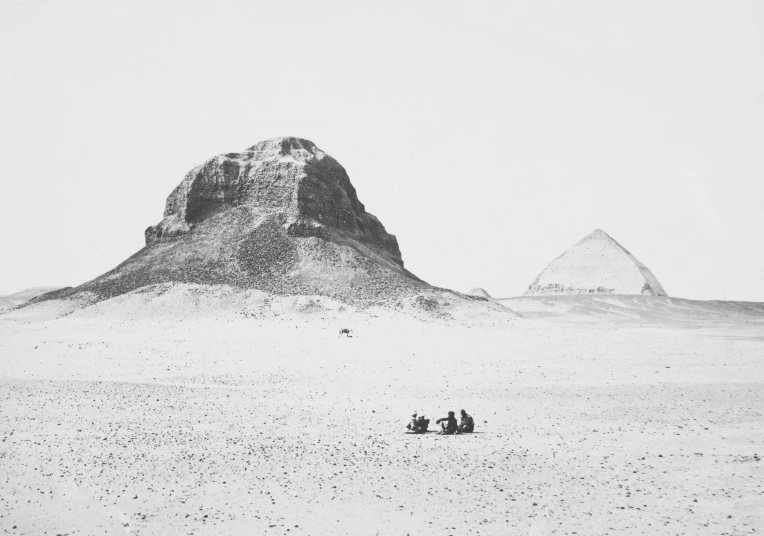 a man and two women riding horses through a desert