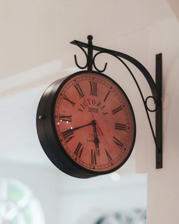 an old clock hangs on a wall with a black cket