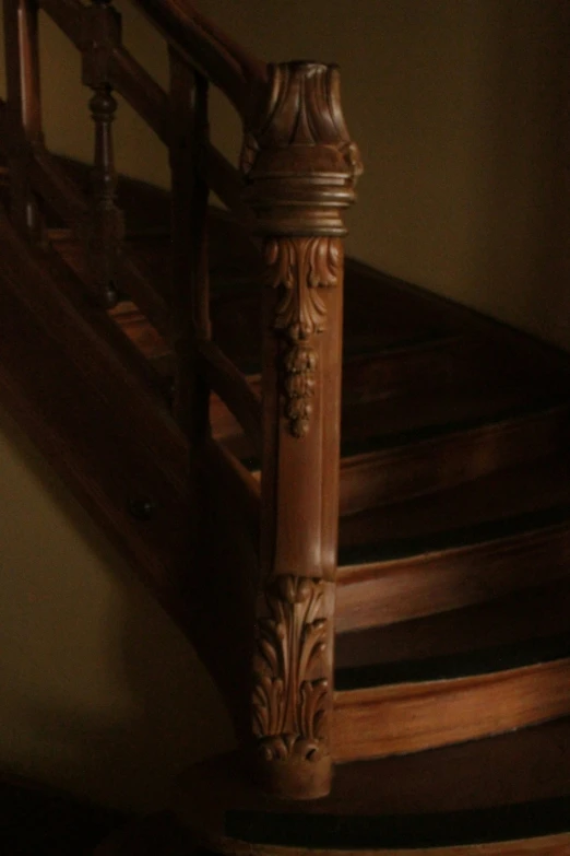 an old looking wooden stair railing in a house