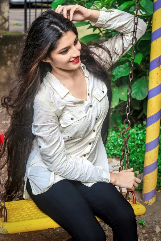 a woman with long hair sitting on a swing