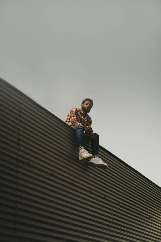 a man that is sitting on top of a roof