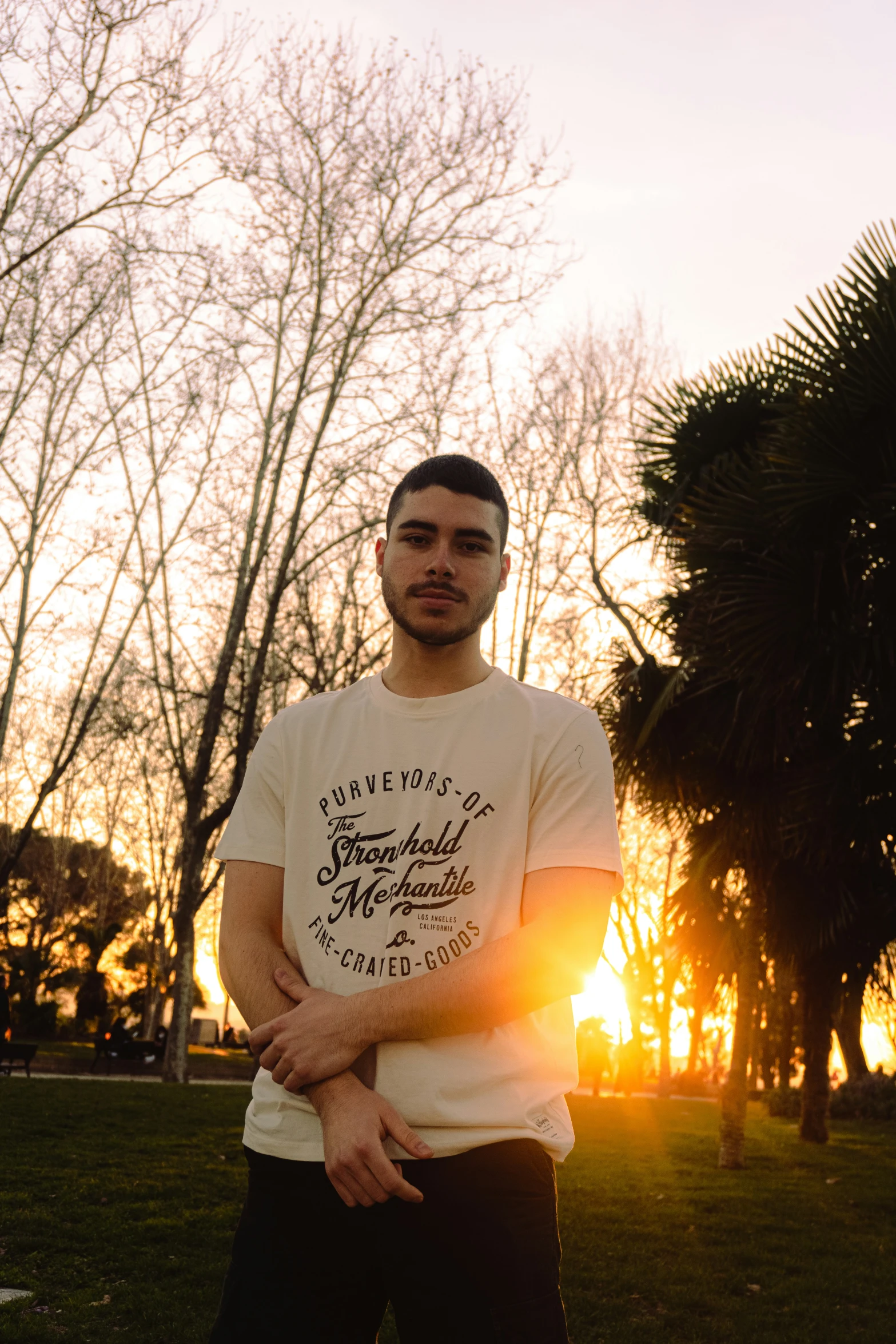 a man is standing outside wearing a white shirt