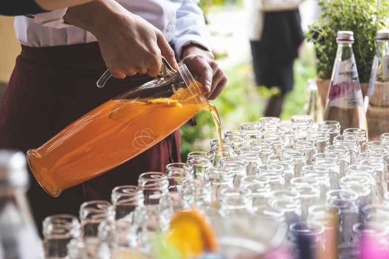 a bartender fills up glasses with lemonade for his guests