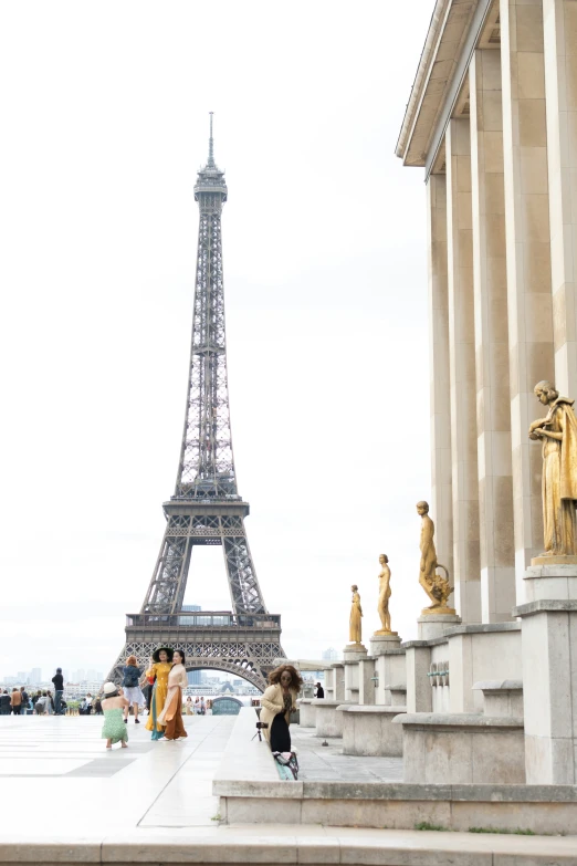 a woman standing next to the eiffel tower