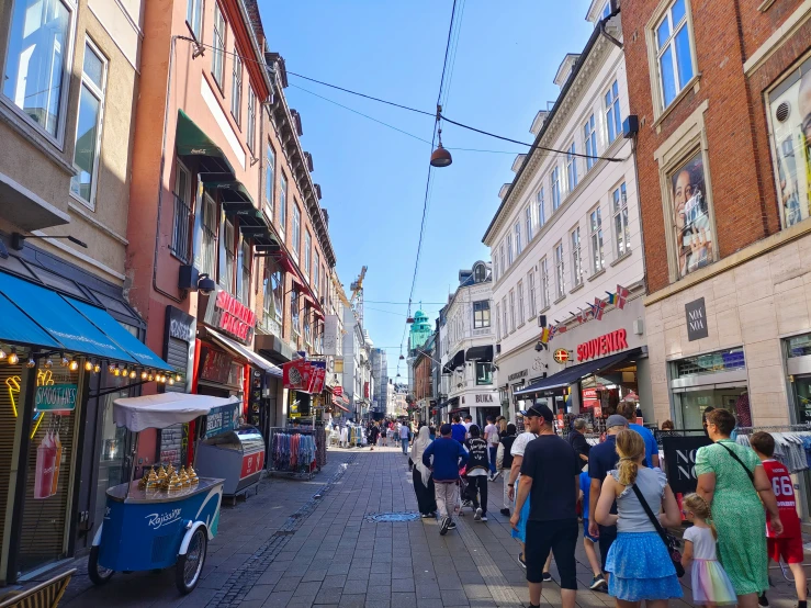 the crowd is walking through the city on a sunny day