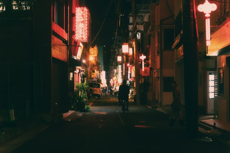 a narrow alley leading into an asian city at night