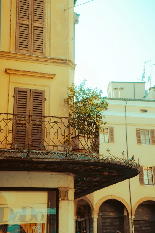 the corner of a building with a balcony and two people on motorcycles