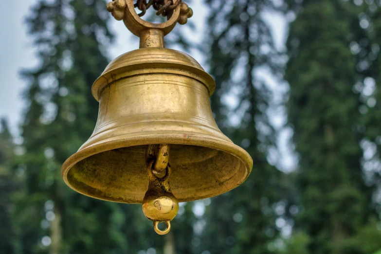 a golden bell is on the side of a pole