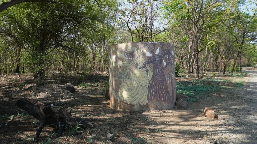 there is a painted rock with trees in the background