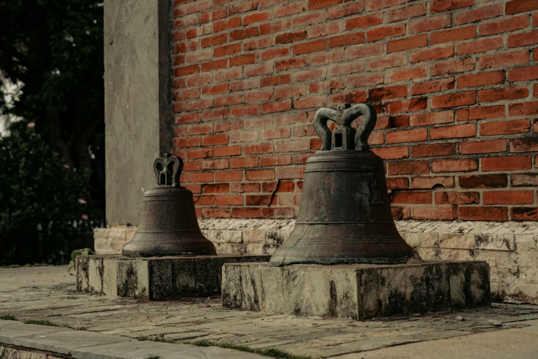 two very large bells sitting on the sidewalk