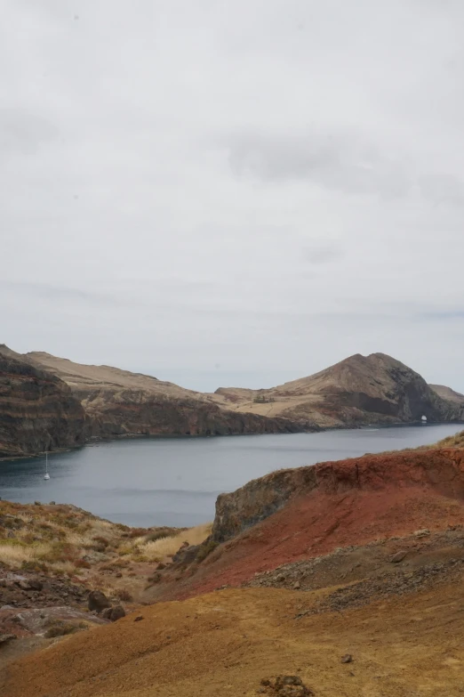 a scenic view of a mountain lake surrounded by barren land