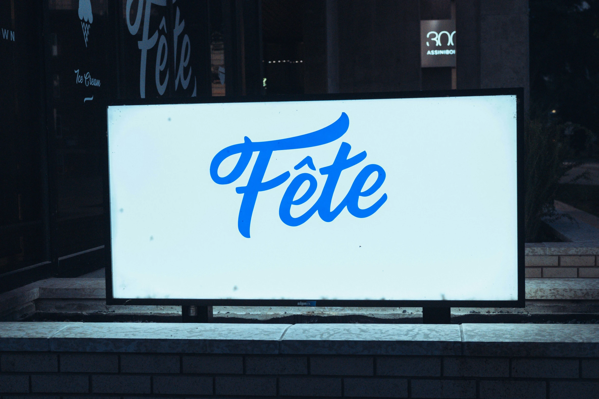 large sign with blue lettering on brick wall