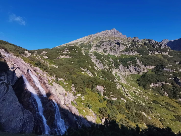 view of the upper slopes of the mountain with the high peak of a nearby cliff