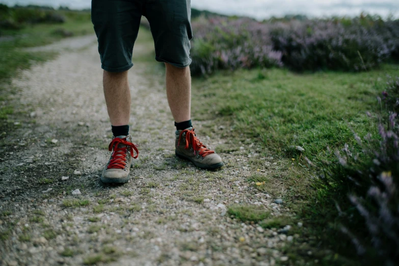 a person in hiking gear stands on a gravel road