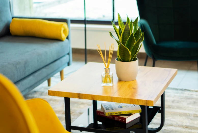 a vase filled with plants sitting on top of a wooden table