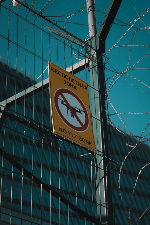 a barbed wire fence and no fly zone sign