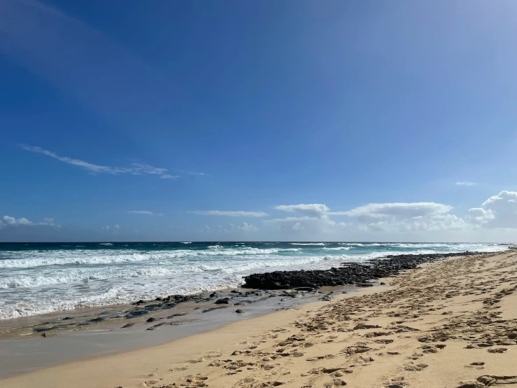 an empty beach with a very sandy shoreline and small waves